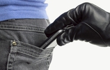 Mit schwarzem Handschuh geschützte Hand zieht einer Frau ein Smartphone aus der Gesäßtasche. (Bild: cunaplus / fotolia)
