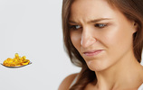 Eine Frau blickt skeptisch auf einen Löffel mit mehreren Tabletten. Bild: puhhha / Fotolia.com