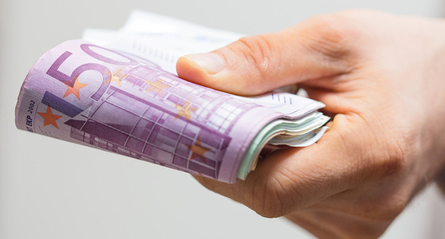 Hand hält gefaltetes Bündel mit Euro-Geldscheinen. Bild: vege / Fotolia