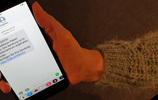 Smartphone in einer Hand zeigt betrügerische SMS von "TrackInfo". Bild: Verbraucherzentrale NRW