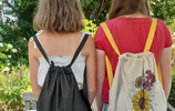 Zwei Mädchen von hinten fotografiert, beide tragen Rucksäcke auf ihren Rücken. Foto: Katja Goebel