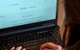 Frau mit Laptop gibt "Online-Banking" in Suchmaschine ein. Foto: Verbraucherzentrale NRW