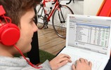 Junger Mann mit Kopfhörer am Laptop. Bild: VZNRW